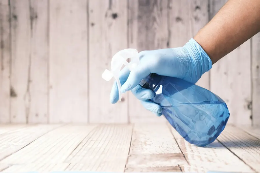 Désinfection des surfaces avec gants et vaporisateur par Netex